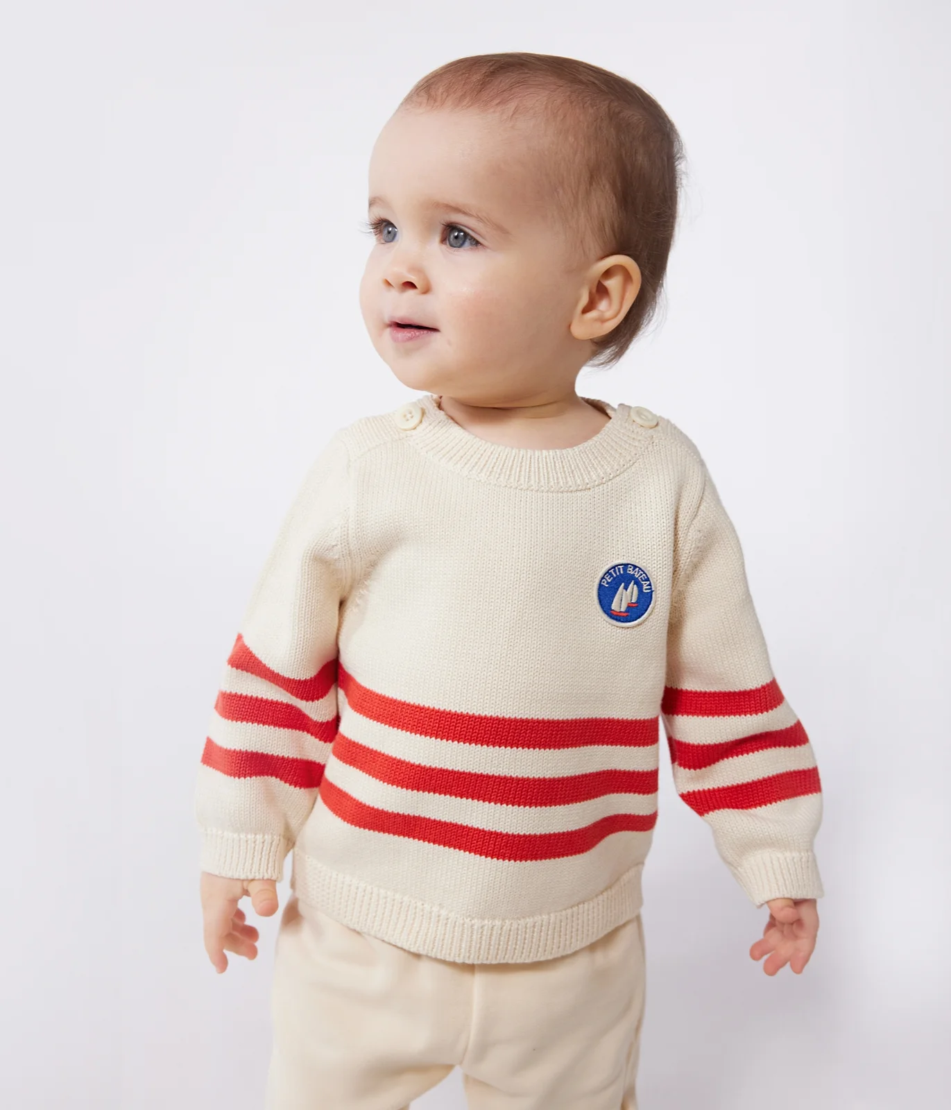 Babies' cotton jumper with placed stripes and a badge on the chest