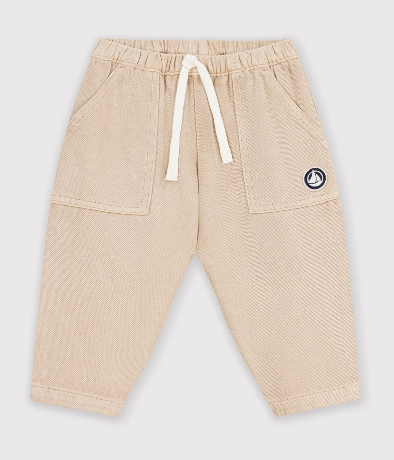 Babies' cargo-style trousers in plain cotton with a badge