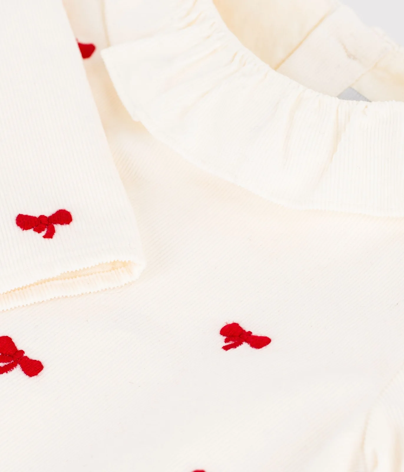 Babies' blouse in velour embroidered with a bow motif