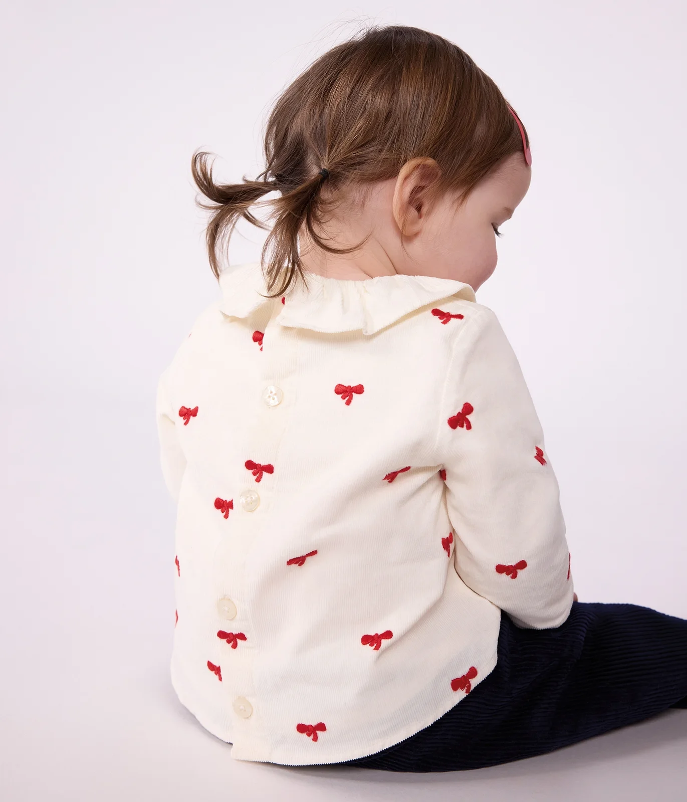 Babies' blouse in velour embroidered with a bow motif