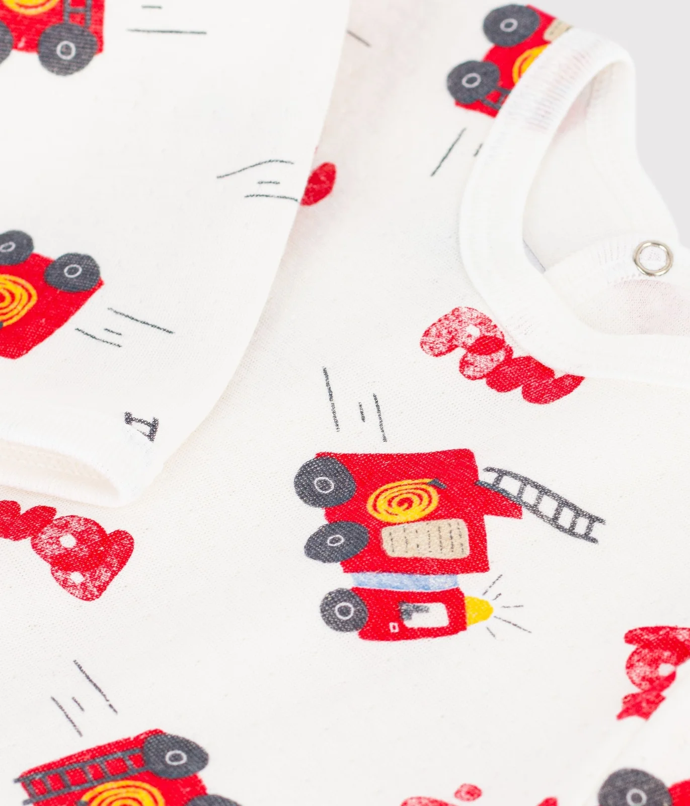 Babies' pyjama suit in tube knit fabric with a printed firefighter design and a back opening