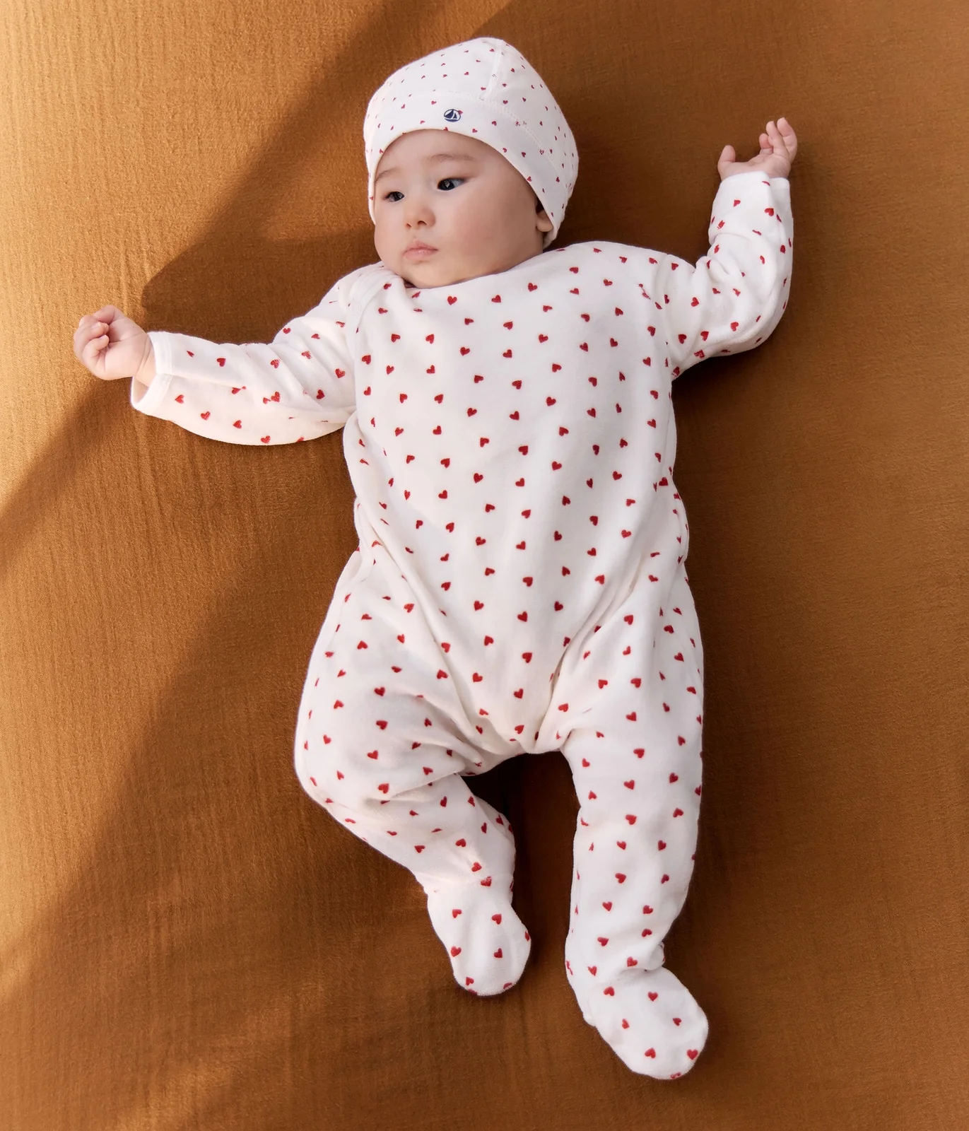 Unisex baby sleepsuit in Velour with a small heart print