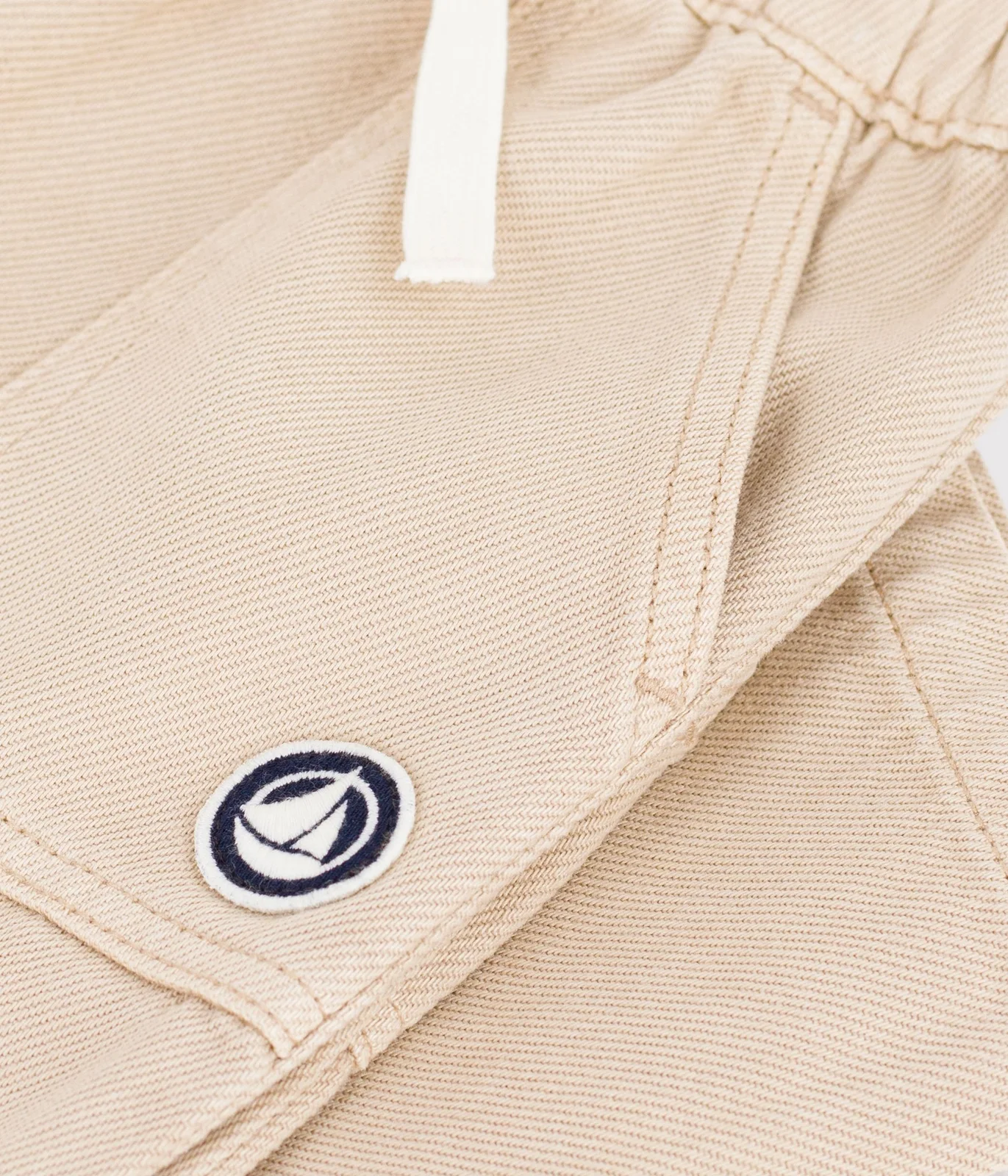 Babies' cargo-style trousers in plain cotton with a badge