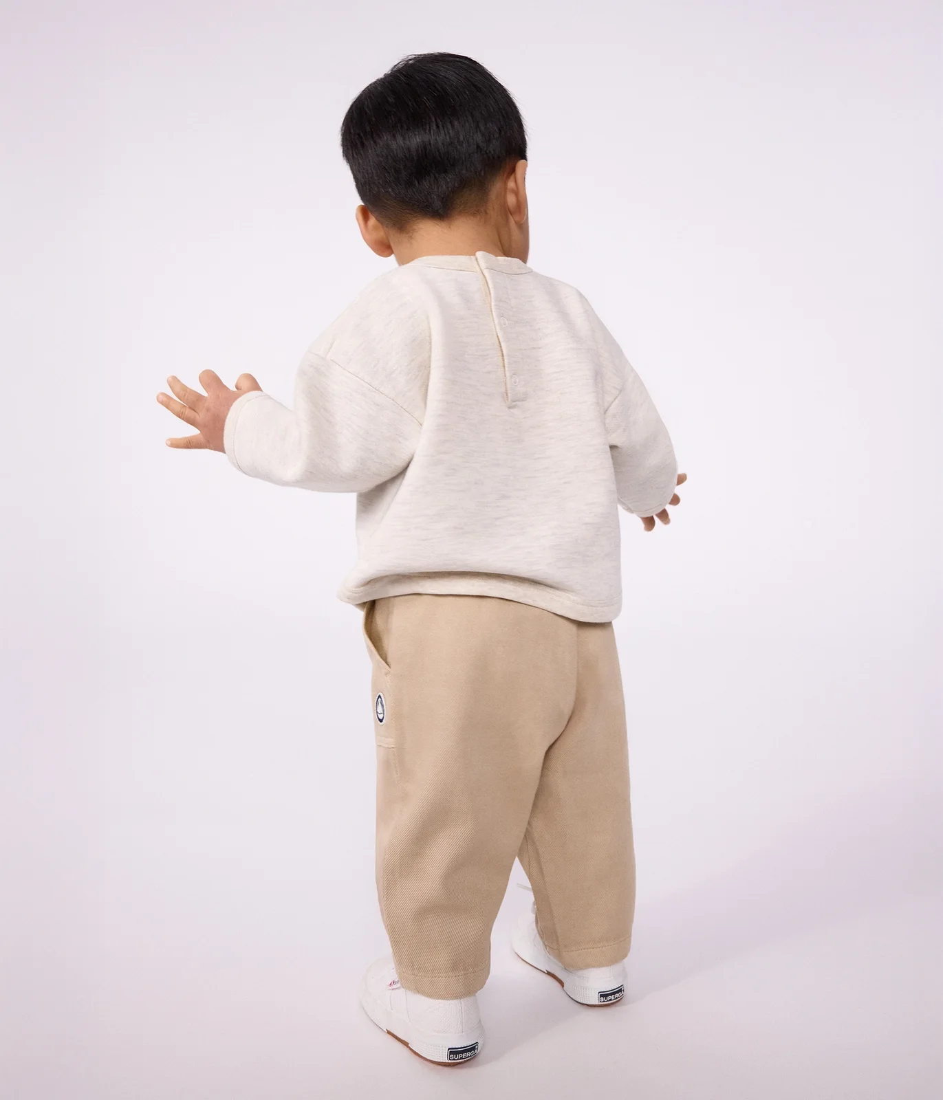 Babies' cargo-style trousers in plain cotton with a badge